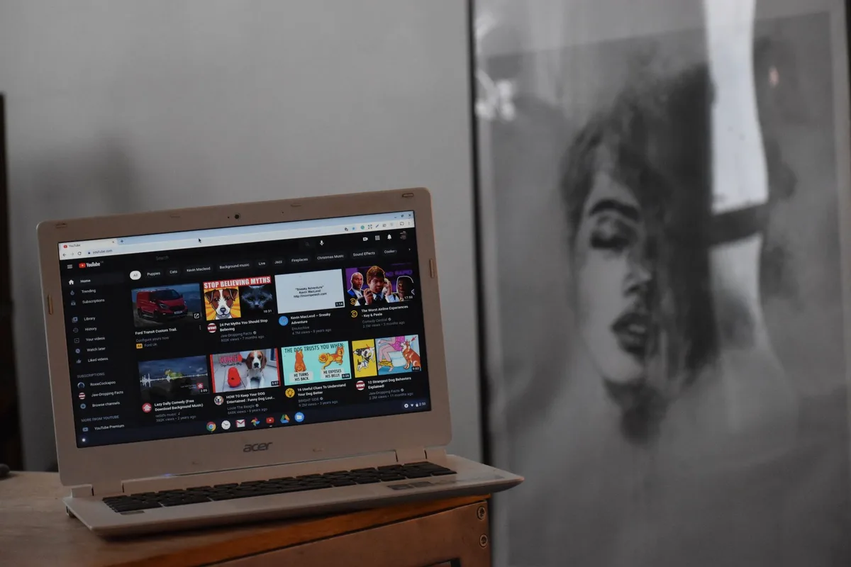 Artist browsing platform options beside a laptop and artwork