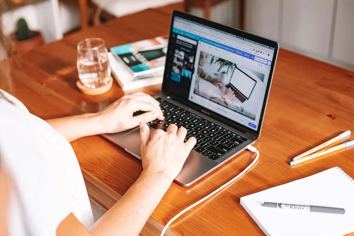 Person working from home on a laptop at a clean wooden desk