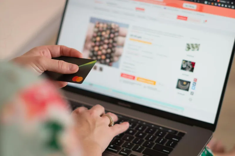 Person browsing Etsy listings for digital downloads on a laptop