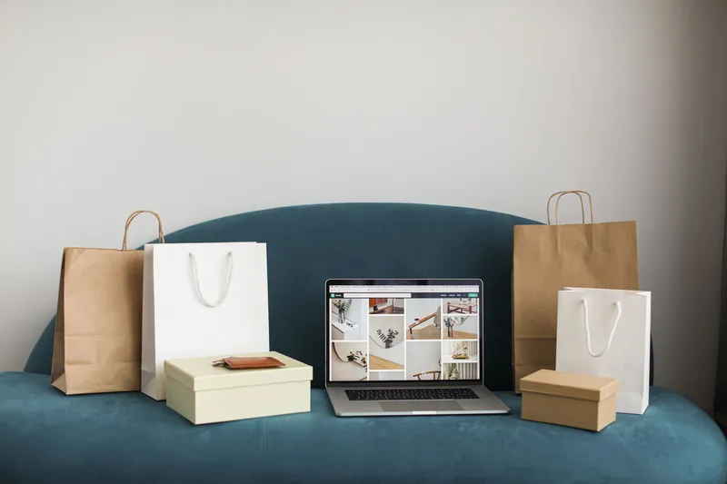 Laptop surrounded by shopping bags representing online selling and ecommerce