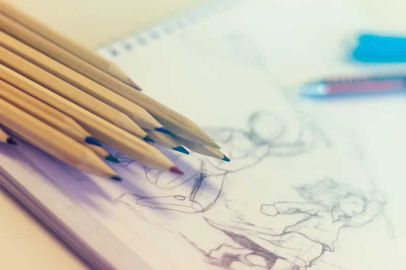Colored pencils and sketchbook for illustration and creative design work