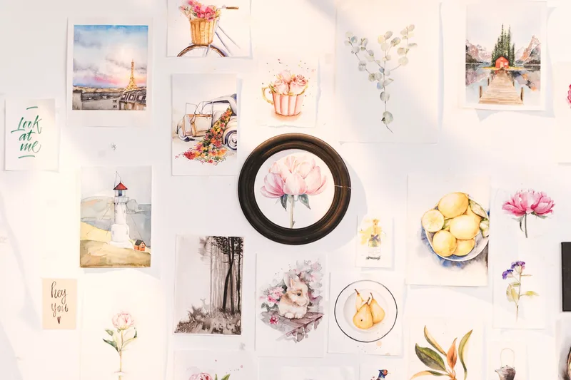 Art prints and paintings displayed in a gallery-style arrangement on a wall