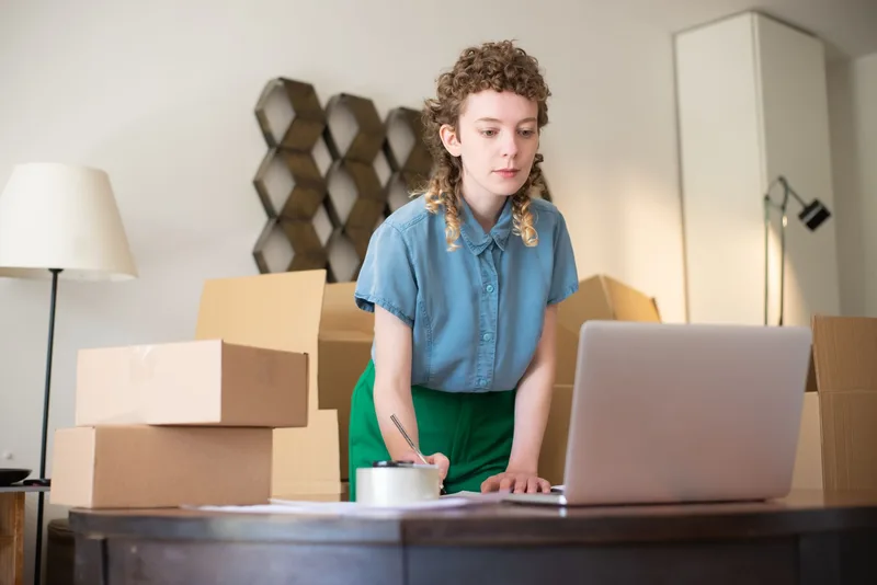 A woman working on her laptop, representing digital product business operations