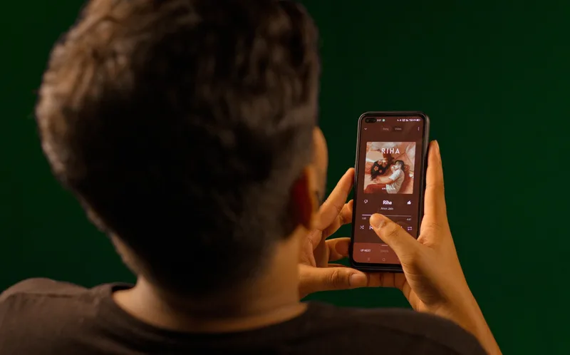 Person listening to music on a smartphone showing a streaming app interface