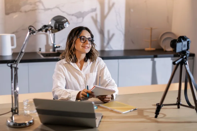 A focused creator at a clean desk taking notes and working on a laptop, building and refining a digital template product