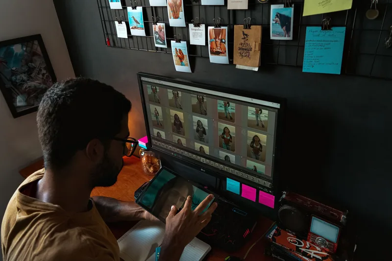 Photographer reviewing and selecting stock photos on a computer screen in a home office