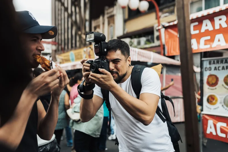 Photographer capturing outdoor street photography scenes with a DSLR camera