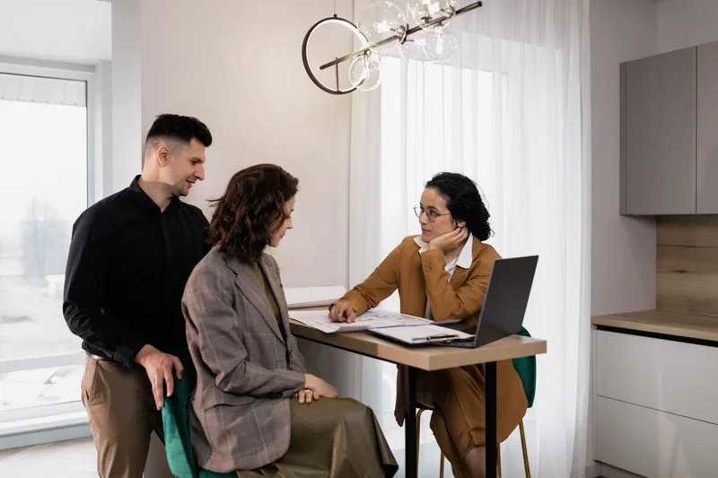A real estate agent consulting with clients in an office, the kind of profession-specific workflow a niche business template is built around