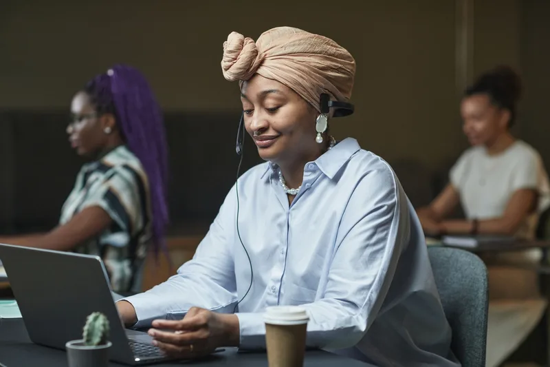 Customer support agent wearing a headset while working on a laptop
