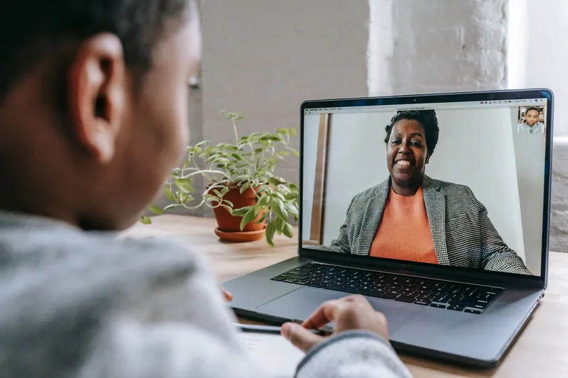 Student attending an online tutoring session over video call on a laptop