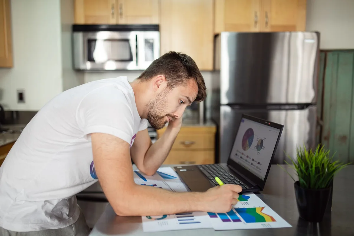 Person reviewing sales charts on a laptop at a home desk