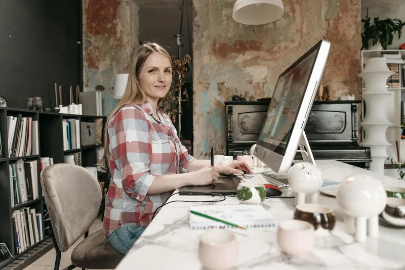 Woman working at a laptop in a modern office setting representing digital seller workflow