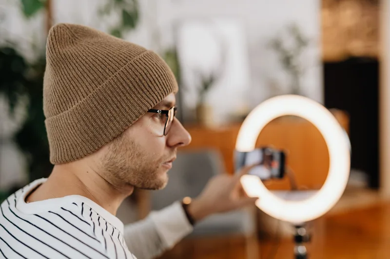 Creator recording an online course lesson on a laptop with a ring light